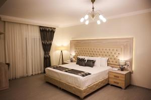 a bedroom with a large bed and a chandelier at Famissi Suites in Kalabaka +22 photos