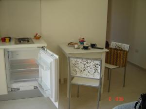 a small kitchen with a table and a refrigerator at Il Sole Il Mare Il Vento in Torre Lapillo