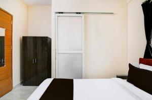a bedroom with a white bed and a closet at Eco Greenway Inn in New Town +4 photos