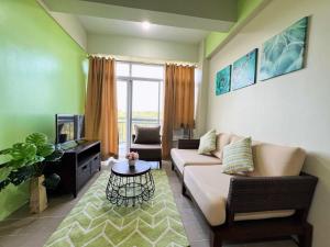 a living room with a couch and a tv at Sharon's Island - Newcoast Boracay in Boracay
