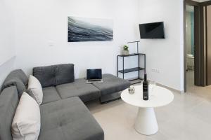a living room with a couch and a table at Georgia apartments and suites in town in Skiathos