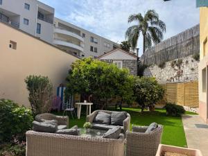 a garden with chairs and a table in a building at La maison de Julia menton studio bleuté in Menton