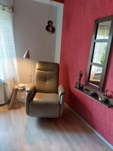 a chair in a room with a pink wall at Ferienwohnung Loose in Tecklenburg +15 photos