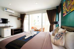 ein Schlafzimmer mit einem Bett, auf dem Handtuchtiere abgebildet sind in der Unterkunft OK Phuket in Kata Beach + 66 Fotos