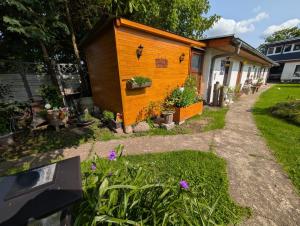 a small wooden house with flowers in a yard at Bungalow bei Warnemünde in Elmenhorst
