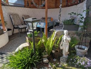 a garden with a statue in a room with plants at Bungalow bei Warnemünde in Elmenhorst +9 photos