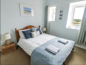 a bedroom with a bed with two towels on it at Lady of the Lake Suite in Holyhead