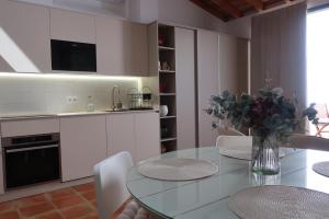 a kitchen with a glass table with a vase of flowers at Oliva Lofts & Beach in Oliva +12 photos