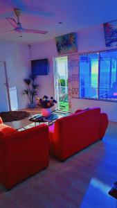 Una sala de estar con un sofá rojo y una mesa. en Sunset Roof, en Margate