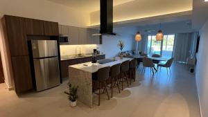 a kitchen with a large island in a kitchen with a table at Departamento TerraMar Flamingos in Nuevo Vallarta