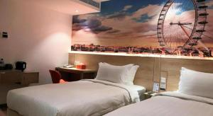 a hotel room with two beds and a ferris wheel on the wall at London Hotel in Macau