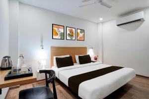 a bedroom with a large bed and a desk with a chair at Super Townhouse Gomti Nagar Sector 6 Near Ekana Stadium in Lucknow