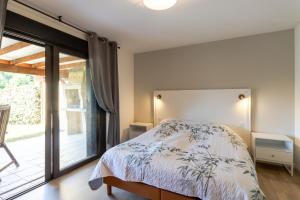 a bedroom with a bed and a sliding glass door at Maison Liz in Castelnaud La Chapelle +14 photos