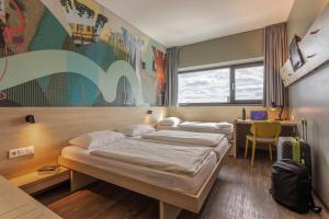 Postel nebo postele na pokoji v ubytování MEININGER Hotel Berlin Airport