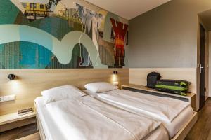 Postel nebo postele na pokoji v ubytování MEININGER Hotel Berlin Airport