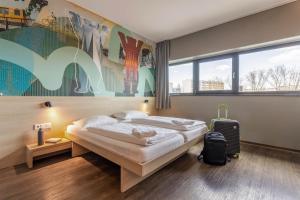 Postel nebo postele na pokoji v ubytování MEININGER Hotel Berlin Airport