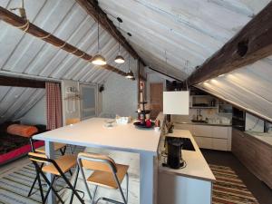a kitchen and living room with a table and chairs at Lägenhet-vindsvåning i centrala öregrund in Öregrund