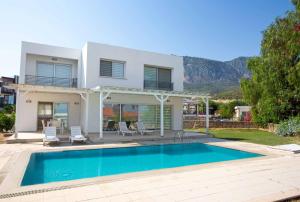 a villa with a swimming pool in front of a house at Bitter Orange Villa with Pool by HolidayKeys in Kyrenia