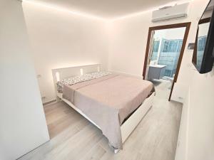 une chambre blanche avec un lit et un miroir dans l'établissement Il Posticino House in Marina, Garden and Veranda, à Marina di Massa