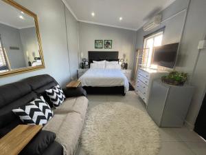 a living room with a bed and a couch at Garden View Cottage in Durban