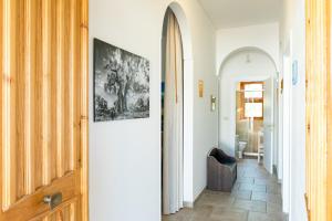 a hallway with a door and a chair in a room at Vittorio Brandi's Villa with Spa, Fitness & Wine Tasting in Ostuni +30 photos