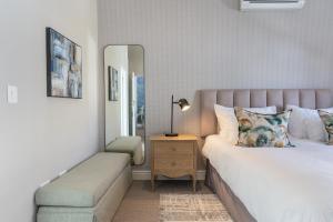 a bedroom with a bed and a table with a mirror at Winelands Golf Lodges 39 in Stellenbosch