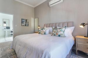 a bedroom with a large white bed with pillows at Winelands Golf Lodges 39 in Stellenbosch