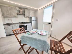 une cuisine avec une table avec deux assiettes dessus dans l'établissement Il Posticino House in Marina, Garden and Veranda, à Marina di Massa