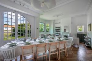 a large white dining room with a table and chairs at Villa de charme classée à Tharon Plage pour 14 in Tharon-Plage
