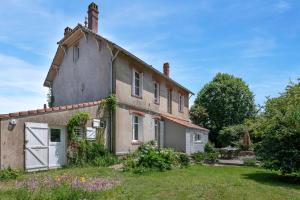 an old stone house with a white door and a yard at Villa de charme classée à Tharon Plage pour 14 in Tharon-Plage