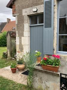 a gray garage door with pots of flowers on a window at Rural House near Sancerre 2 bedrooms in Feux