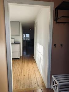 a hallway of a kitchen with a wooden floor at Litet hus nära Värnamo in Hörle +7 photos