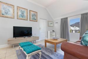 a living room with a couch and a tv at Winelands Golf Lodges 40 in Stellenbosch