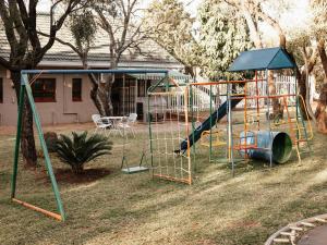 a playground in a yard with a slide at Kudu Kopje Lodge in Kroondal