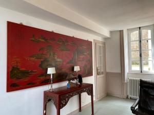 un cuadro en la pared de una habitación con una mesa en Le Parvis, en Granville