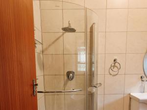 a shower with a glass door in a bathroom at Kudu Kopje Lodge in Kroondal +24 photos