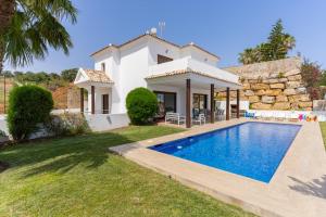 una villa con piscina frente a una casa en Chalet En La Cala De Mijas Costa, en Mijas Costa