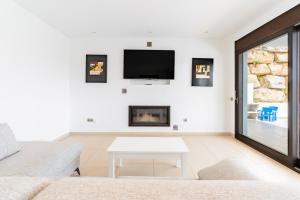 sala de estar con chimenea y TV en la pared en Chalet En La Cala De Mijas Costa, en Mijas Costa