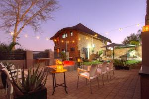 a patio with chairs and a table and a building at Stay at Royal in Marloth Park