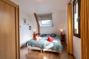 una camera da letto con un letto con cuscini rossi e una finestra di Maison Rose a Castelnaud-la-Chapelle Altre 12 foto