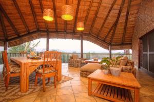 a patio with a table and chairs and a roof at Stay at Royal in Marloth Park