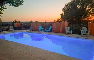 - une piscine avec des chaises et un coucher de soleil en arrière-plan dans l'établissement La Magnanerie, à Ruoms