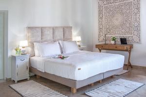 a bedroom with a large white bed and a table at Georgia Villas in Skiathos