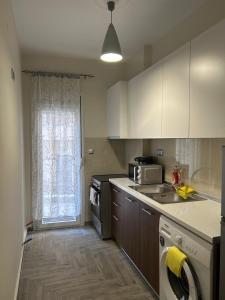 a kitchen with a stove and a sink and a window at The harmony of the center in Kilkís