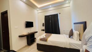 una habitación de hotel con una cama y un televisor en Hotel Airdrome Inn, en Bangalore