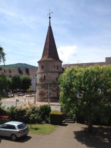 une église avec une croix au sommet d'une tour dans l'établissement Gîte Sonnenberg, à Ammerschwihr