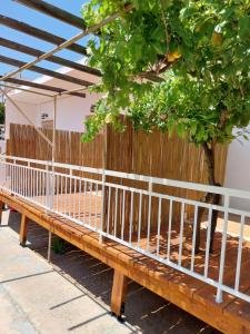 a wooden bench sitting next to a fence at George Apartments in Aegina Town