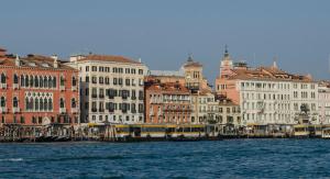 eine Gruppe von Gebäuden neben dem Wasser mit Bussen in der Unterkunft Ca' De Mezo near San Marco in Venedig