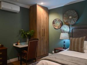 a bedroom with a bed and a desk and a table at Waterwoods Equestrian Venue and Cottages in Nottingham Road +15 photos