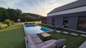 a backyard with a swimming pool and a house at Midnight Villa in Cerkvenjak